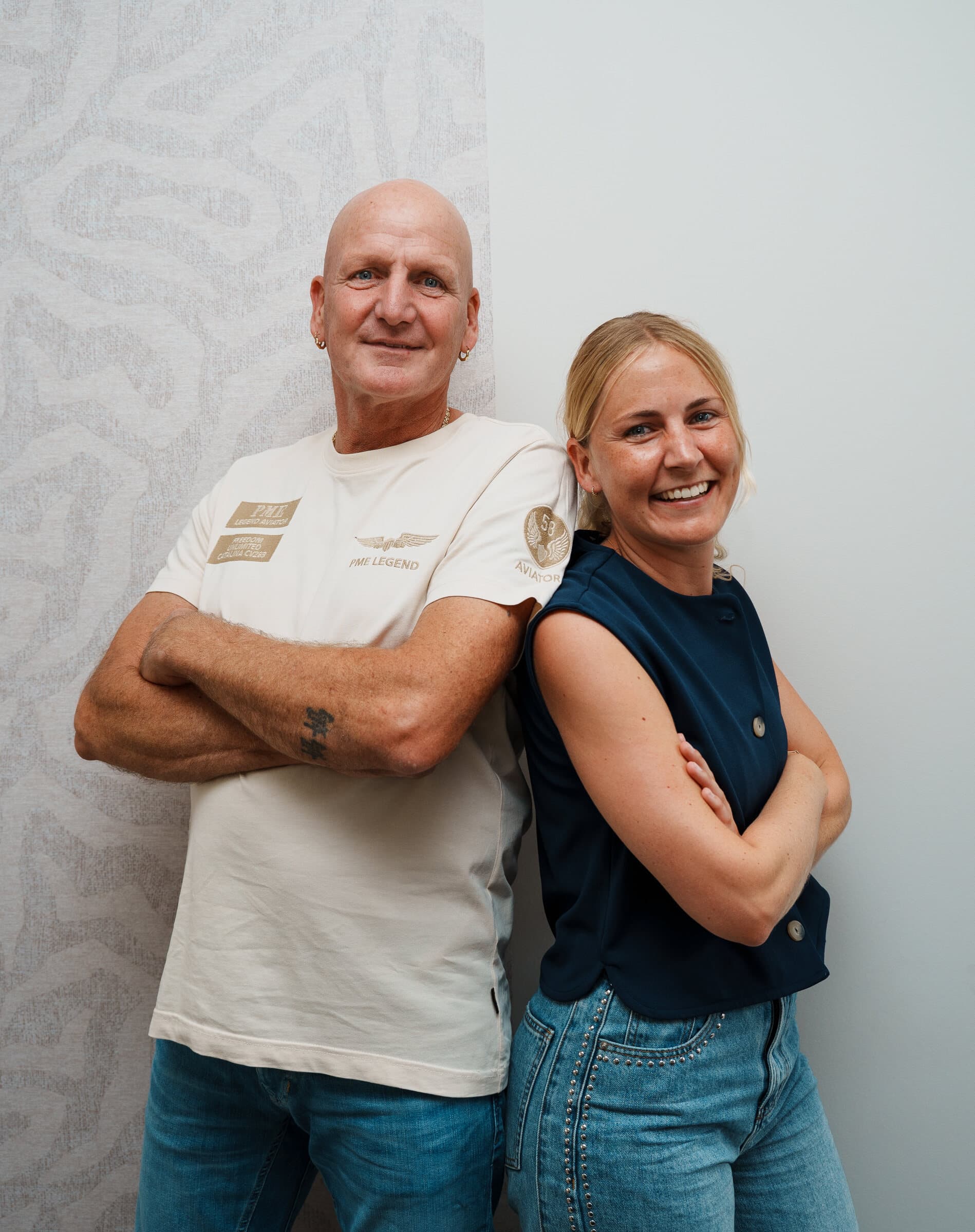 Nikki en Leen rug aan rug voor een lichte wand