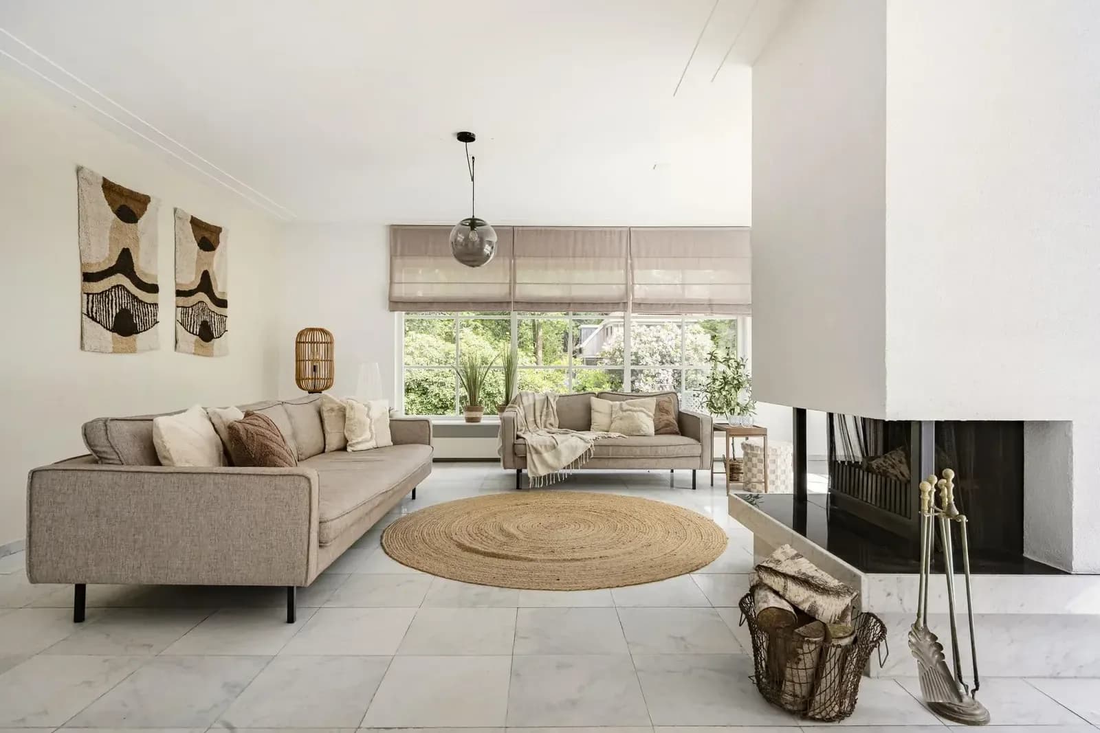 Gestylede woonkamer met bank, haard en rond jute vloerkleed