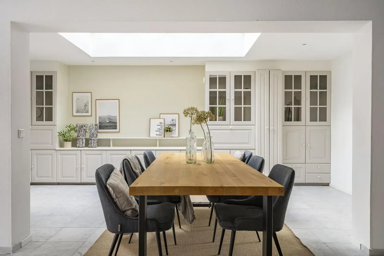 Eetkamer met lange tafel onder een lichtkoepel, klaar voor de foto's