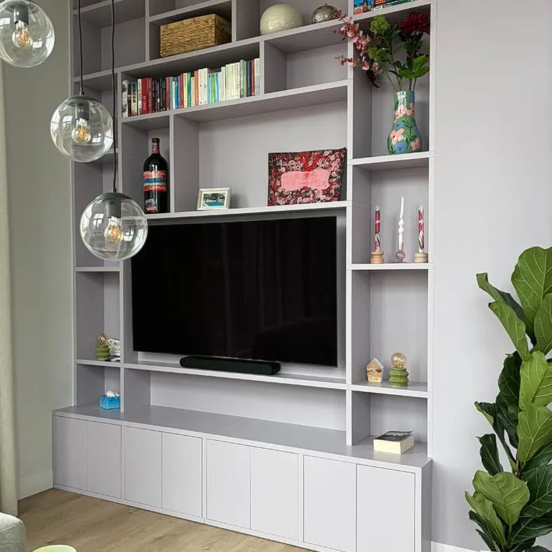 Lichtgrijze wandkast op maat met televisie, boeken en accessoires
